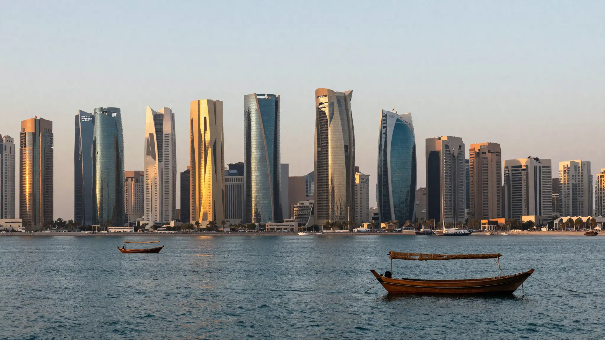 منظر بانورامي لأبراج الدوحة الحديثة في منطقة الخليج الغربي عاصمة قطر عند الغروب مع الكورنيش البحري ومياه الخليج العربي